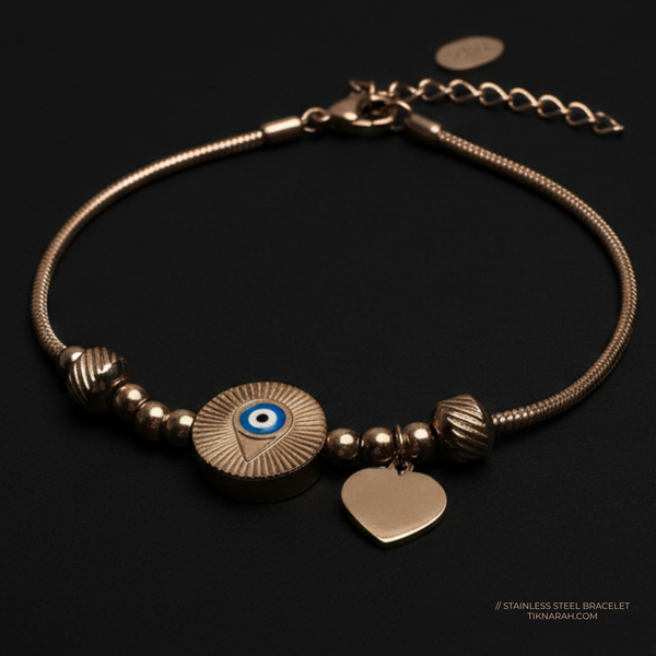 Bracelet with eye charm and heart pendant on a dark background Rose gold evil eye bracelet
Protective nazar jewelry
Tarnish-free rose gold bracelet
Evil eye charm snake chain
Waterproof protection jewelry
Spiritual aesthetic accessories
Rose gold heart and eye bracelet
Hypoallergenic evil eye jewelry
Meaningful jewelry gift for her