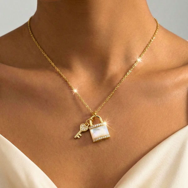 Gold necklace with a lock and key pendant on a person wearing a white Pearl padlock necklace, gold key and lock pendant, heart key charm necklace, celestial jewelry, romantic anniversary gift, iridescent shell necklace, pavé crystal lock jewelry, vintage style lock necklace.top.