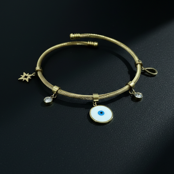 Gold bracelet with charms on a black background Evil eye bracelet, gold cable bangle, nazar jewelry, celestial charm bracelet, spiritual protection jewelry, gold cuff bracelet, adjustable jewelry for women, twisted cable bracelet, star charm bangle.