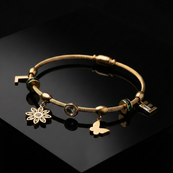 Gold cable bracelet, charm bangle for women, butterfly charm jewelry, floral gold bracelet, emerald green crystal jewelry, personalized initial bracelet, luxury cable bangle, women's fashion accessories, stackable gold jewelry.